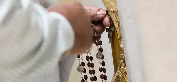 A man touches his rosary to the blood relic